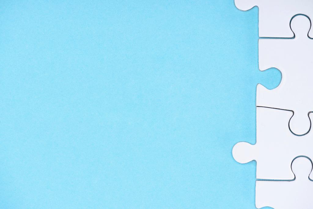 volledige frame van witte puzzels regeling op blauwe achtergrond - Foto, afbeelding