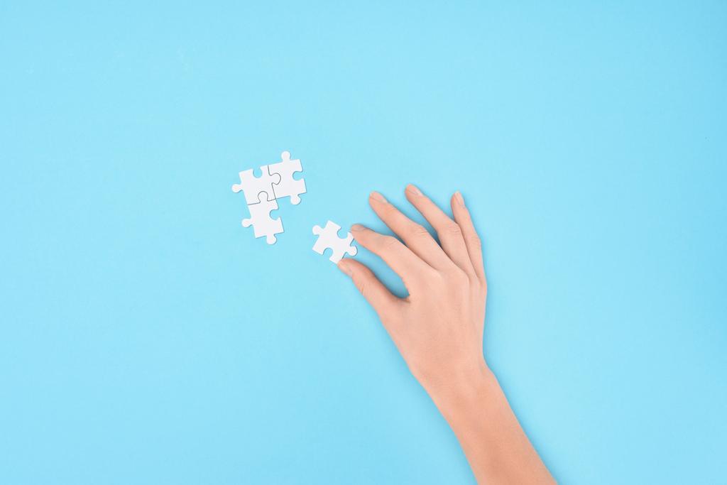 ritagliato colpo di donna con puzzle bianchi pezzi su sfondo blu
 - Foto, immagini