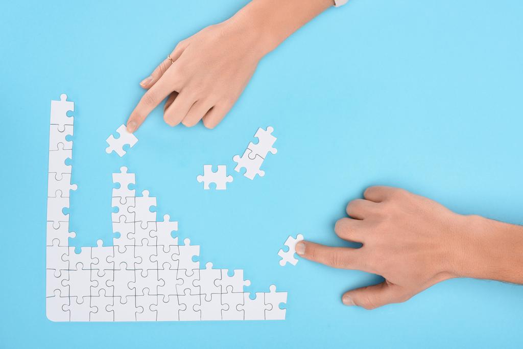 обрезанный снимок мужчины и женщины с белыми кусочками головоломки на синем фоне, концепция сотрудничества
 - Фото, изображение