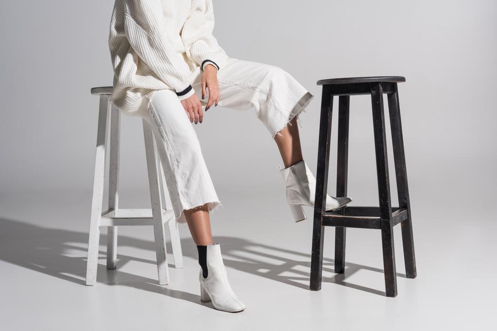 imagen recortada de chica en ropa blanca elegante sentado en silla blanca en blanco
 - Foto, Imagen