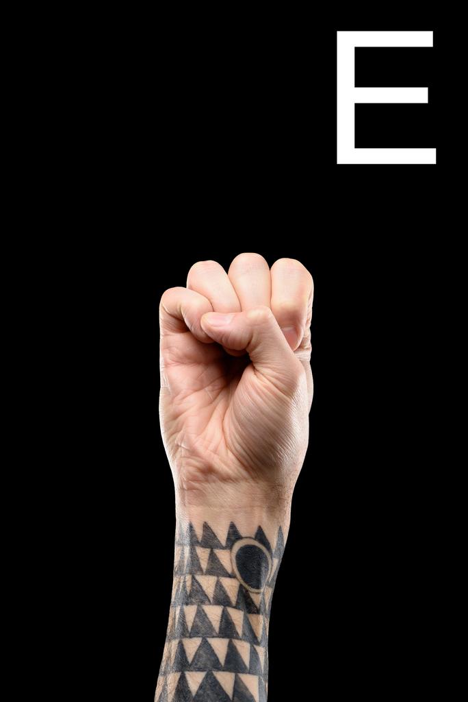 tatuato mano maschile che mostra lettera latina - E, lingua dei segni, isolato su nero
 - Foto, immagini