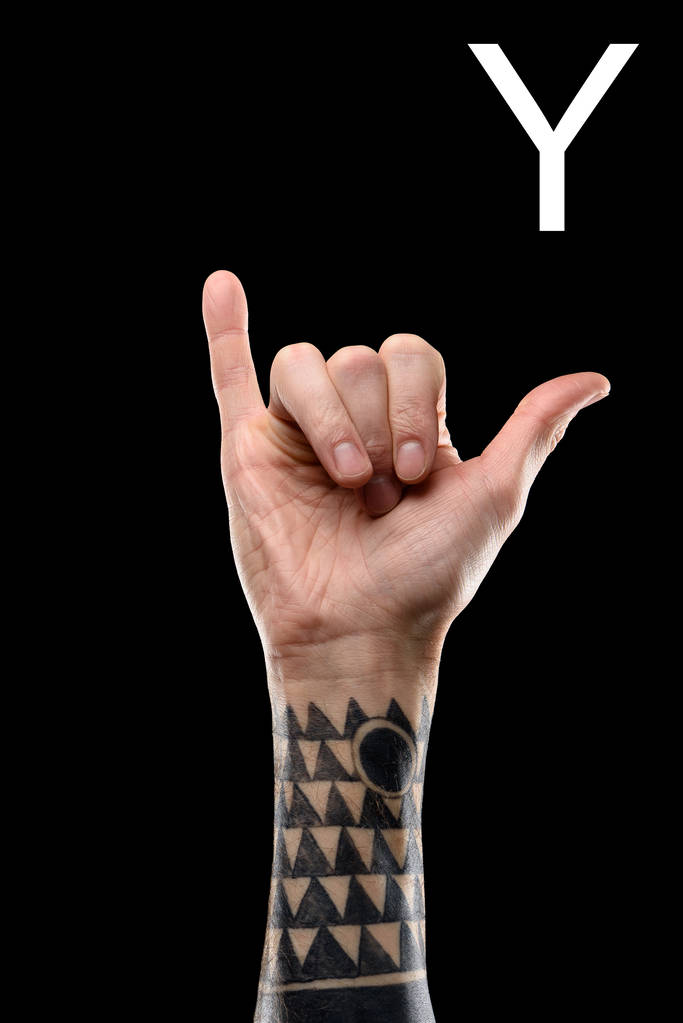 vista parcial de la mano masculina tatuada mostrando la letra latina - Y, lenguaje sordo y mudo, aislado en negro
 - Foto, imagen