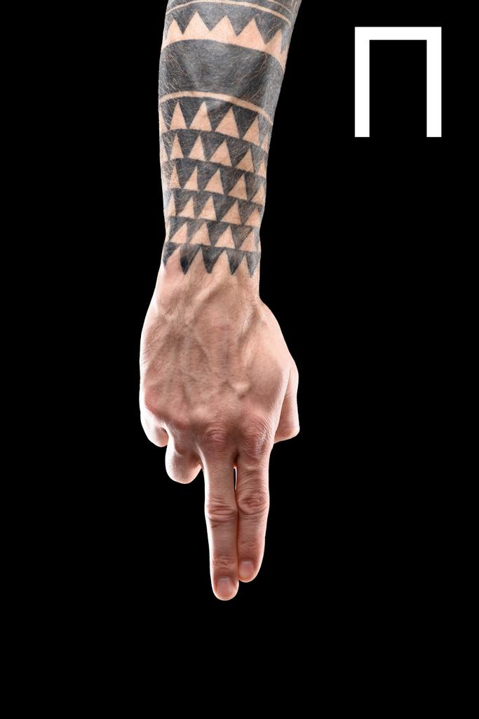 partial view of tattooed hand showing cyrillic letter, deaf and dumb language, isolated on black - Photo, Image