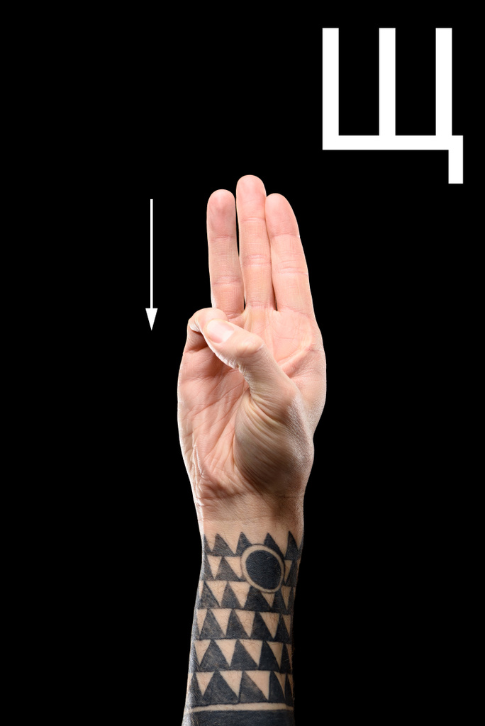 partial view of male tattooed hand showing cyrillic letter, deaf and dumb language, isolated on black - Photo, Image