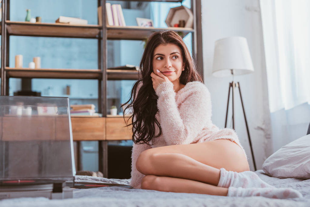 smiling pretty girl sitting on bed and listening vinyl audio player at home - Photo, Image