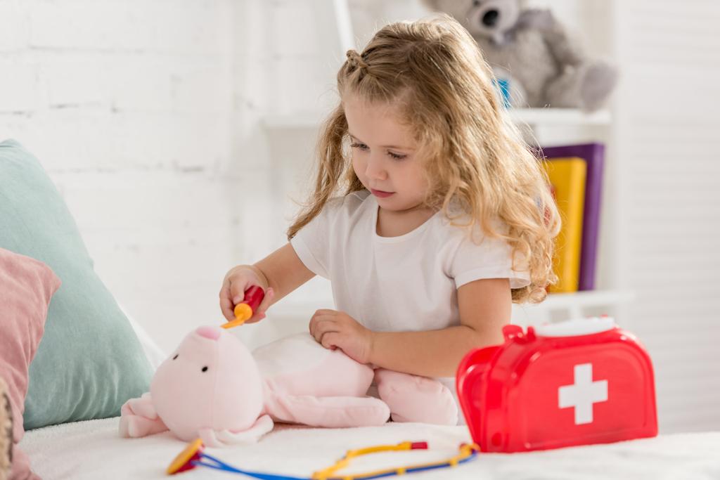 очаровательный ребенок осматривает кроличью игрушку в детской комнате
 - Фото, изображение
