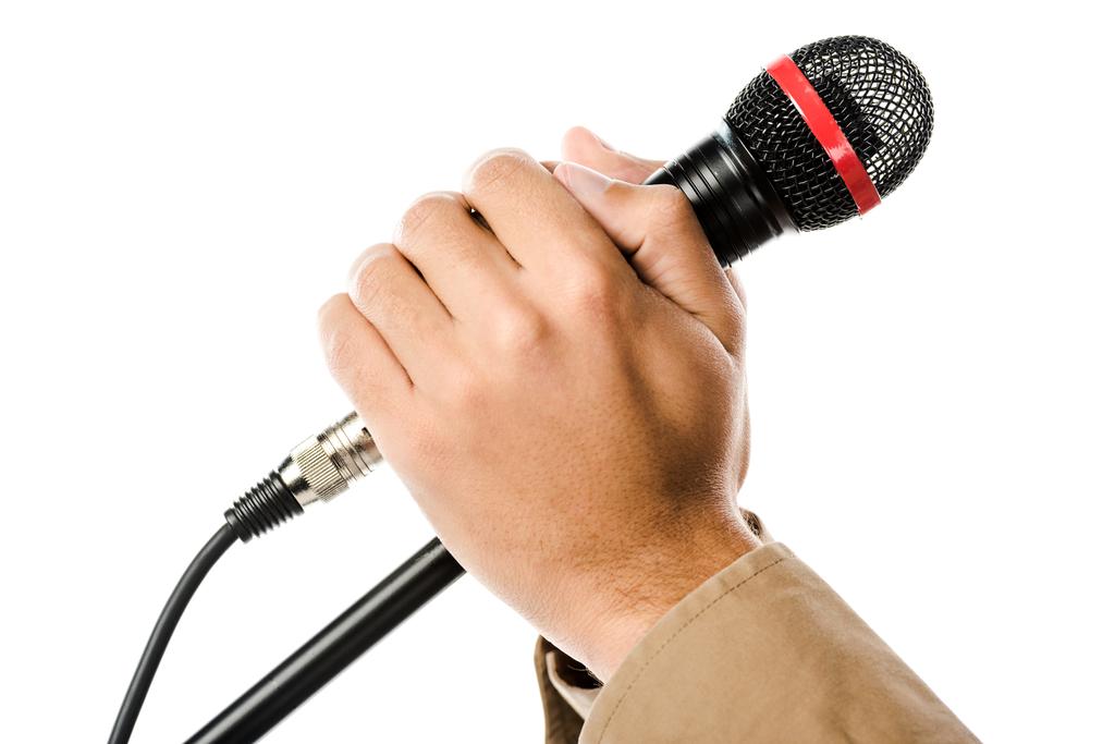 körülvágott kép tartja a kezében a mikrofon elszigetelt fehér férfi zenész - Fotó, kép