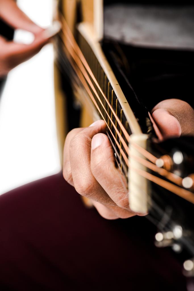 περικομμένη εικόνα αρσενικό μουσικός που παίζει για την ακουστική κιθάρα που απομονώνονται σε λευκό - Φωτογραφία, εικόνα