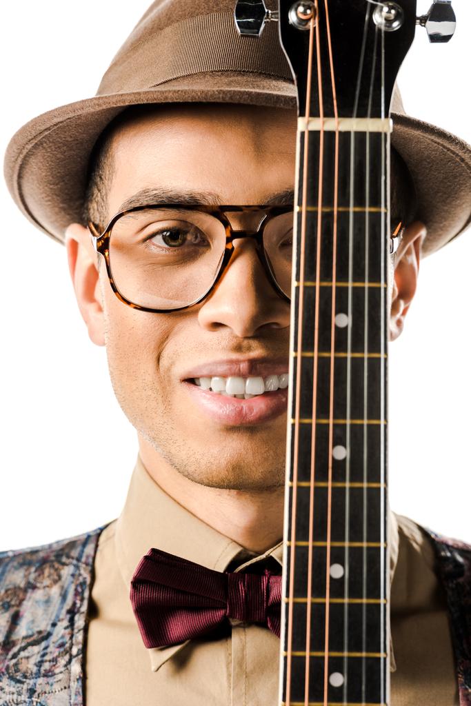 portrait of happy male musician in hat and eyeglasses posing with acoustic guitar isolated on white - Photo, Image