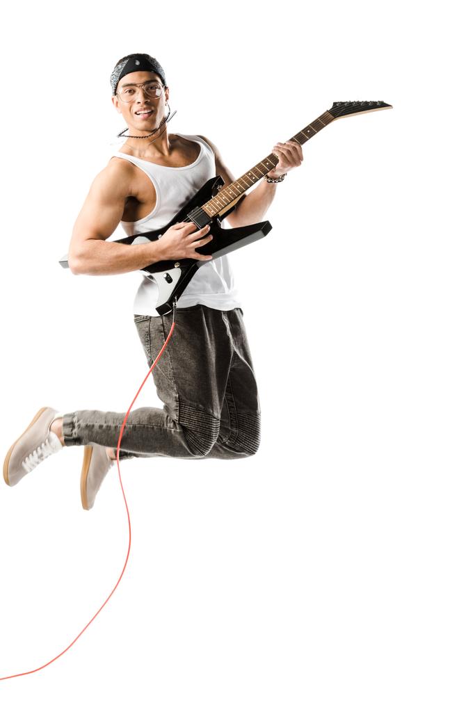 feliz joven rockero macho saltando y jugando en la guitarra eléctrica aislado en blanco
 - Foto, imagen
