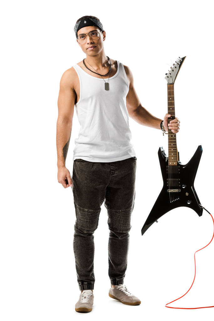 όμορφος αρσενικό ροκ μουσικός ποζάρει με το μαύρο ηλεκτρική κιθάρα που απομονώνονται σε λευκό - Φωτογραφία, εικόνα