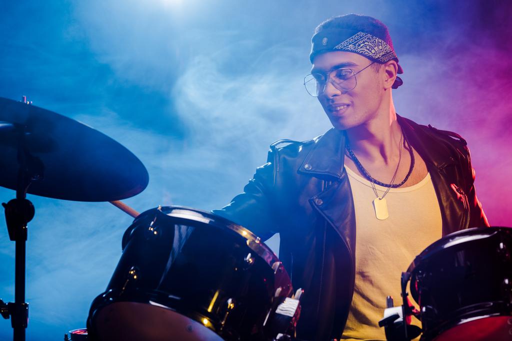 mannelijke musicus gemengd ras drummen tijdens rockconcert op het podium  - Foto, afbeelding