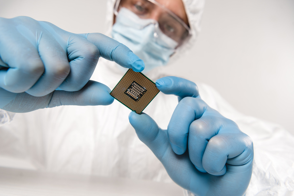 selective focus of microchip in hands of scientist wearing latex gloves, googles and mask on grey background - Photo, Image
