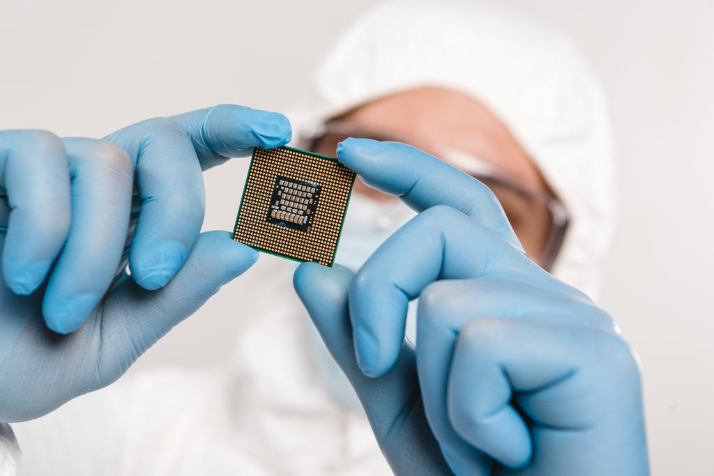 foco seletivo do microchip nas mãos do cientista que usa luvas de látex isoladas em cinza
 - Foto, Imagem