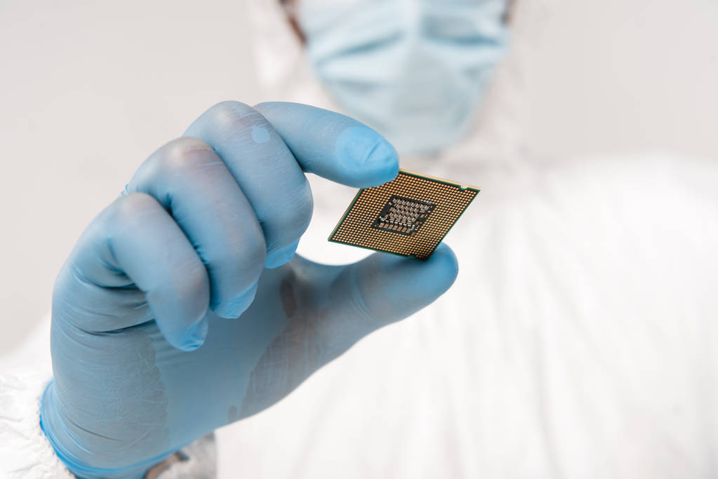 селективная фокусировка микропроцессора в руке ученого, носящего латексную перчатку, изолированную на сером
  - Фото, изображение