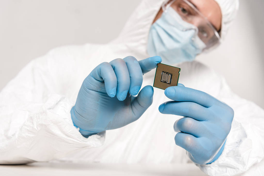 селективний фокус мікропроцесора в руках вченого в окулярах на сірому фоні
 - Фото, зображення