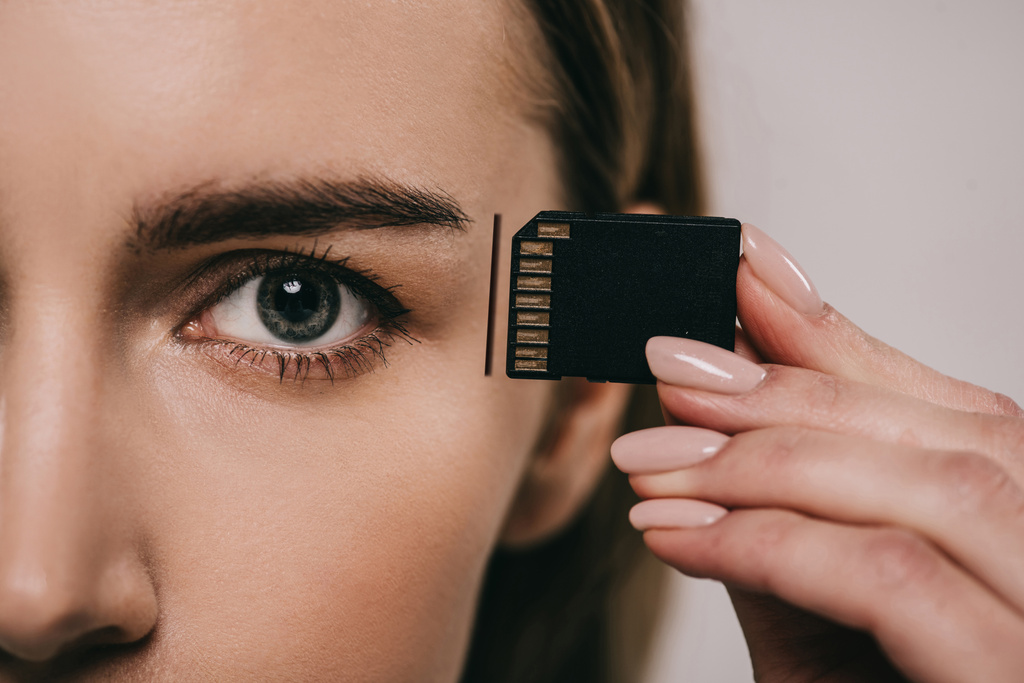 abgeschnittene Ansicht einer Frau mit Mikrochip beim Einsetzen in den Kopf - Foto, Bild