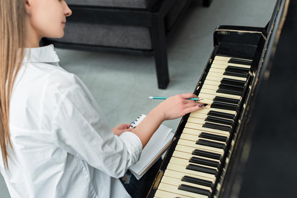 частковим видом дівчата з гри фортепіано ноутбук і написання музики в домашніх умовах - Фото, зображення