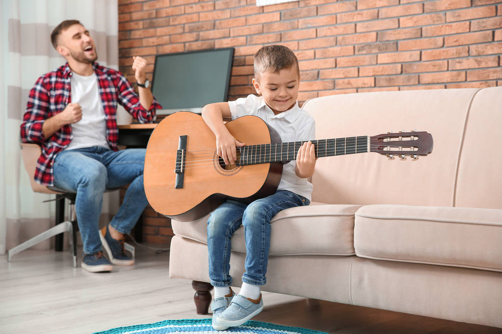 Father and son playing guitar and singing at home - Photo, Image
