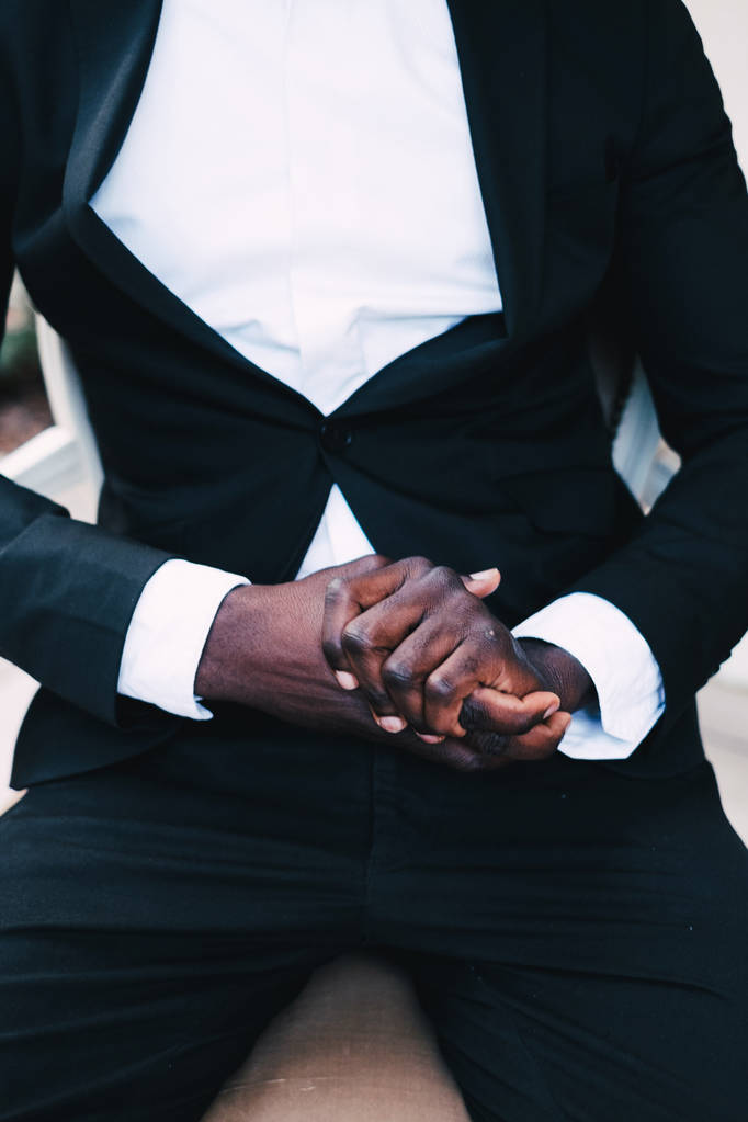 negro hombre en un traje de negocios sentado en una silla
 - Foto, Imagen
