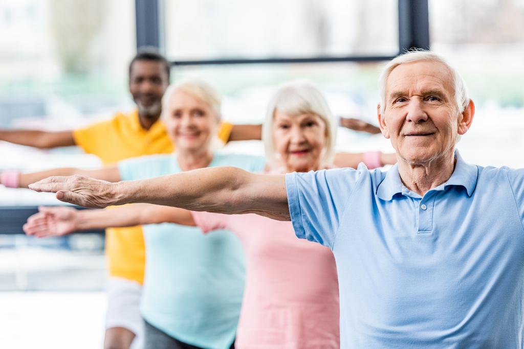 Selektiver Fokus multikultureller Senioren-Athleten beim Synchrontraining im Fitnessstudio - Foto, Bild