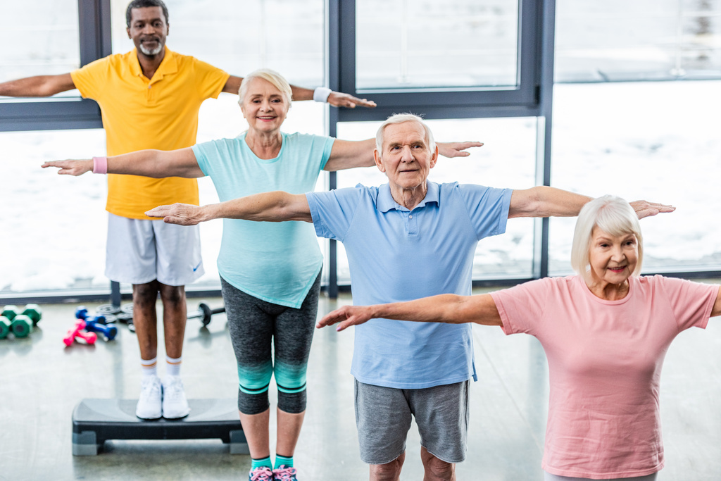 visão de alto ângulo de atletas seniores multiculturais que se exercitam de forma síncrona em plataformas de degrau na sala de esportes
 - Foto, Imagem