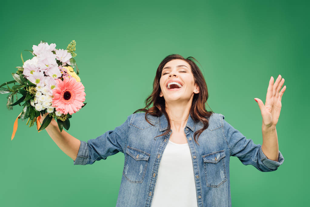 schöne lachende Frau mit Blumenstrauß isoliert auf grün - Foto, Bild