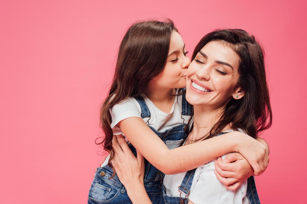 Córka, Całowanie szczęśliwą matką na różowym tle  - Zdjęcie, obraz