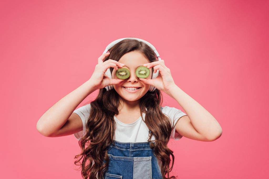 キウイ フルーツ ピンクの分離の目の上に保持している幸せな子供 - 写真・画像