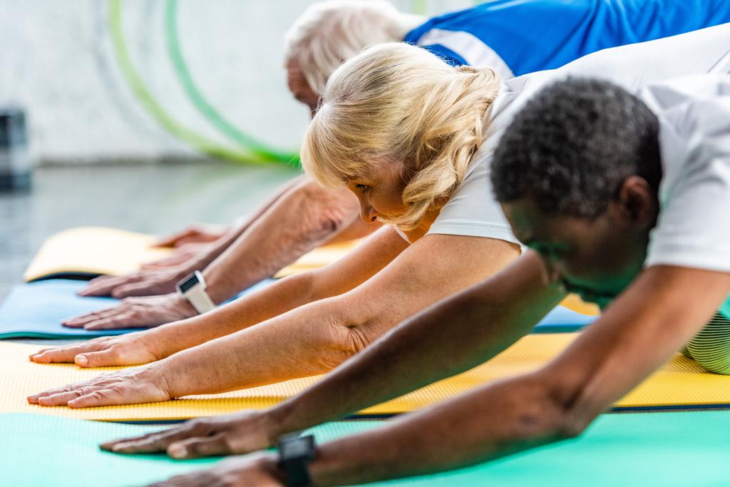 επιλεκτική εστίαση των ανώτερων αθλήτρια άσκηση με τους φίλους σας στο γυμναστήριο - Φωτογραφία, εικόνα