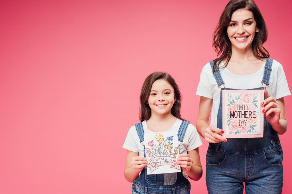 Мать и дочь держат открытки на день матери изолированные на розовый
  - Фото, изображение