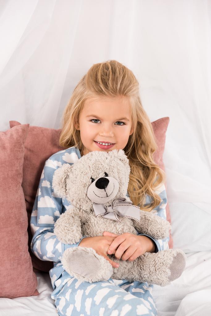 joyeux mignon enfant embrassant ours en peluche au lit
 - Photo, image