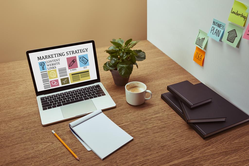 "marketing stratégia" betűk és ikonok-ra képernyő, jegyzetfüzet és ceruza fa asztali, fali matrica laptop - Fotó, kép