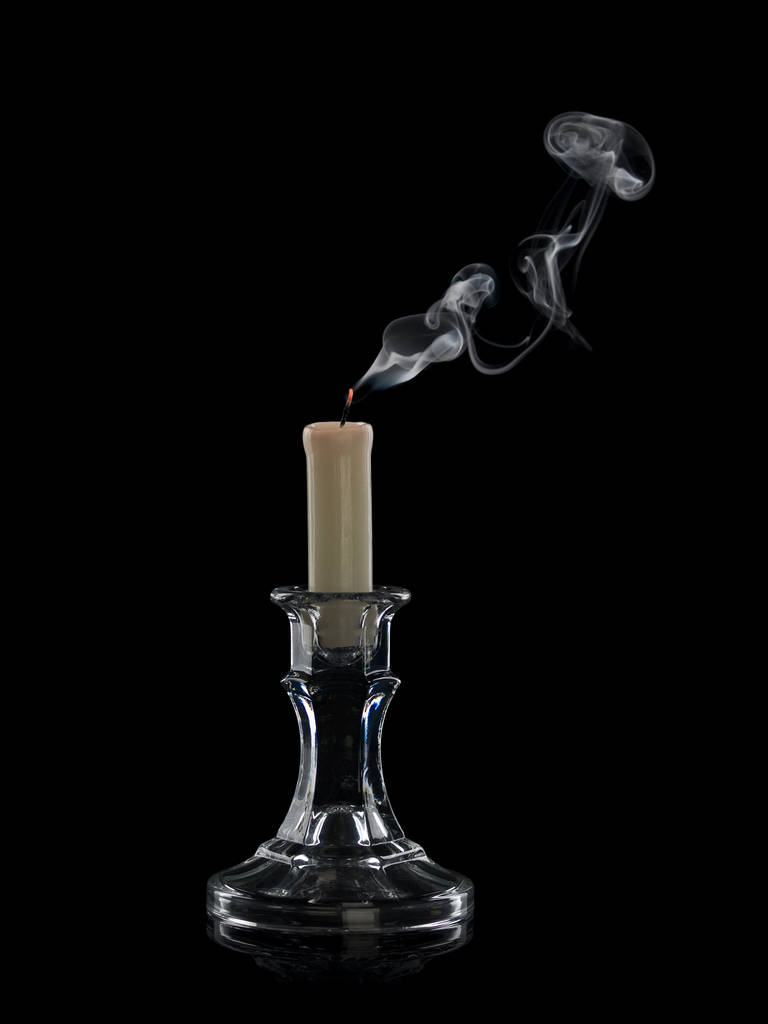 Fumaça da vela extinta em um castiçal de vidro isola-se no preto
 - Foto, Imagem