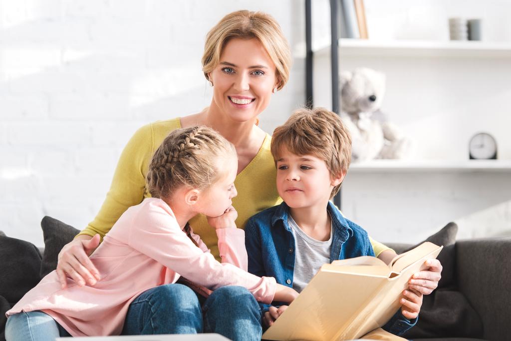 Gelukkig moeder lacht op camera tijdens het lezen van boeken met kinderen  - Foto, afbeelding