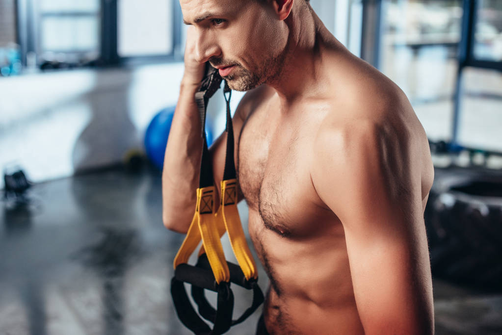 όμορφος μυϊκή shirtless αθλητής κατέχει ζώνες αντίστασης στο γυμναστήριο  - Φωτογραφία, εικόνα
