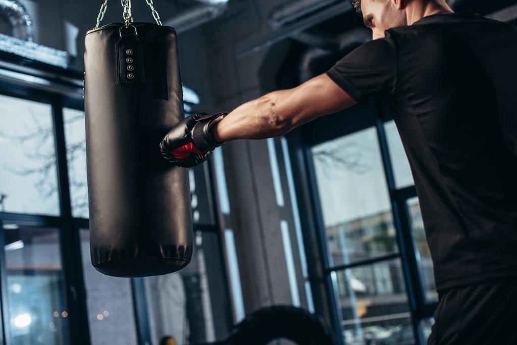 вид сбоку на красивую тренировку боксера с сумкой в тренажерном зале
 - Фото, изображение