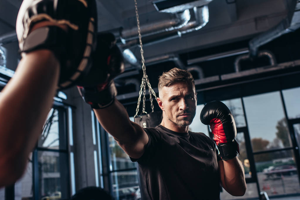 hezký boxer cvičení s trenérem v posilovně - Fotografie, Obrázek