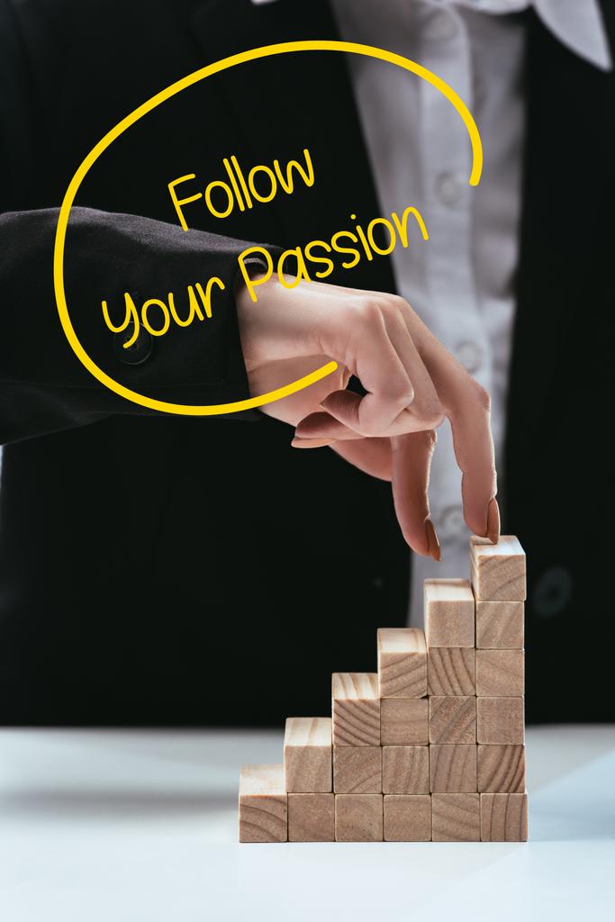 Ausgeschnittene Ansicht einer Frau, die mit den Fingern hölzerne Karriereleiter erklimmt, Schriftzug "Folge deiner Leidenschaft" im Vordergrund - Foto, Bild
