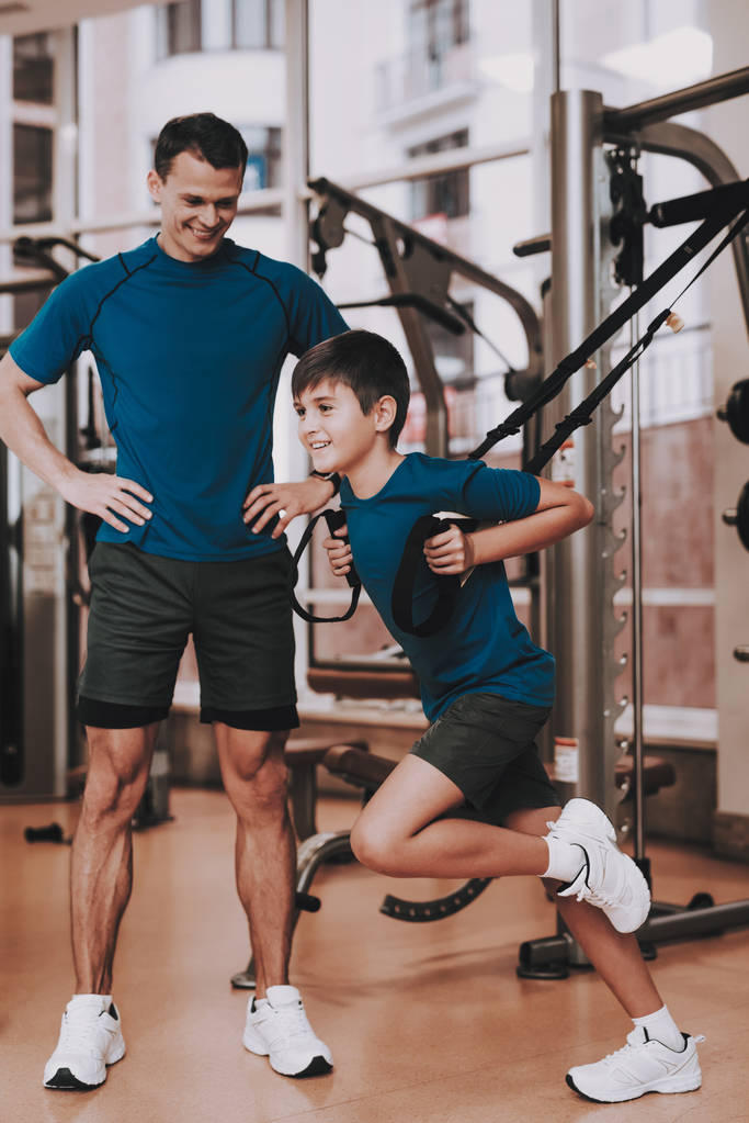 Młody ojciec i syn robi ćwiczenia w Sport Club - Zdjęcie, obraz