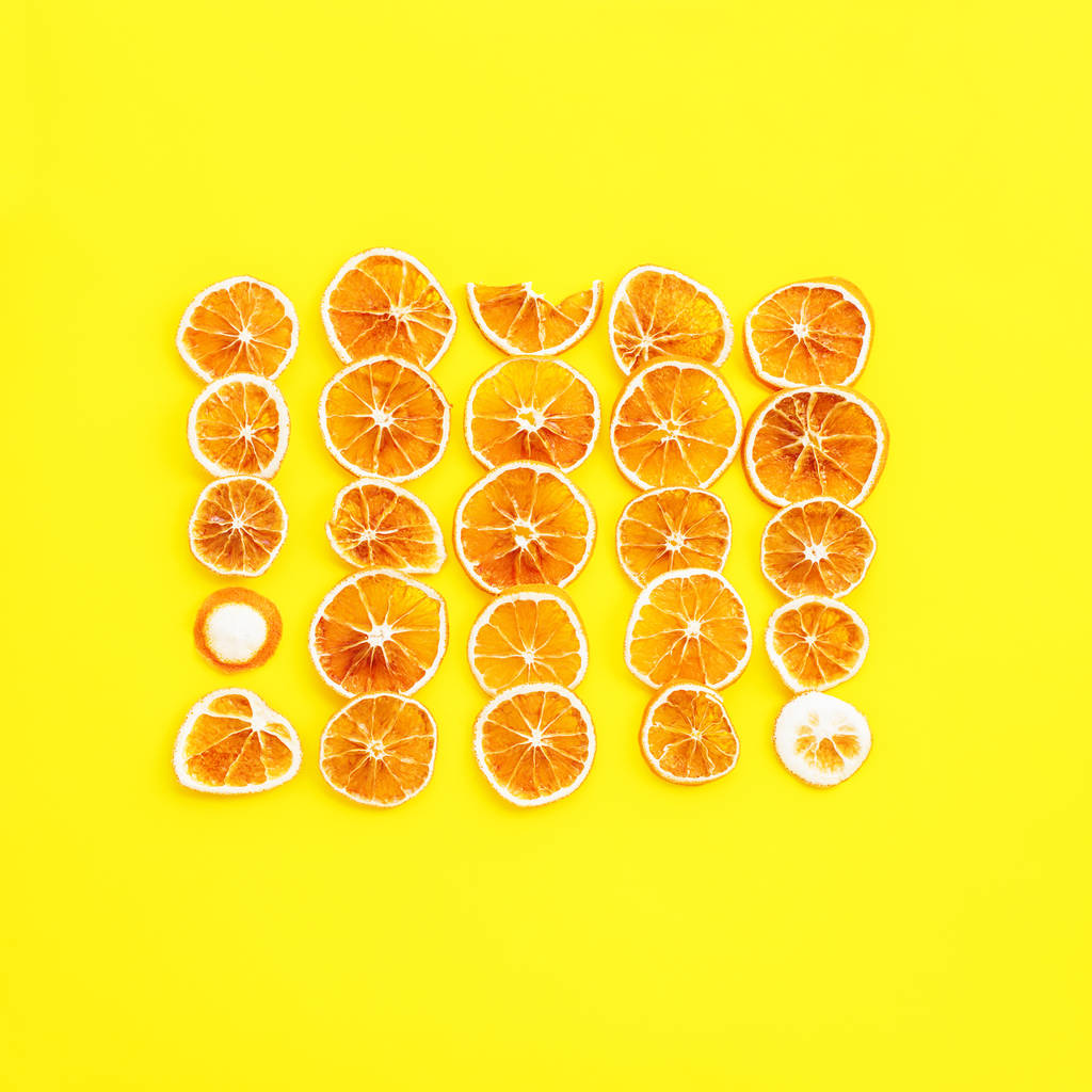 Dried citrus fruit Slices oranges on yellow background Row in square homemade Christmas natural and organic pattern decoration Top view - Photo, Image