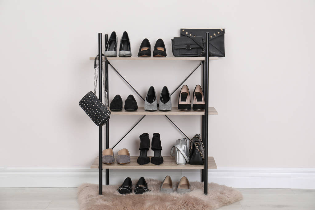 Scaffale con scarpe alla moda e portamonete vicino alla parete bianca. Elemento di spogliatoio interno
 - Foto, immagini