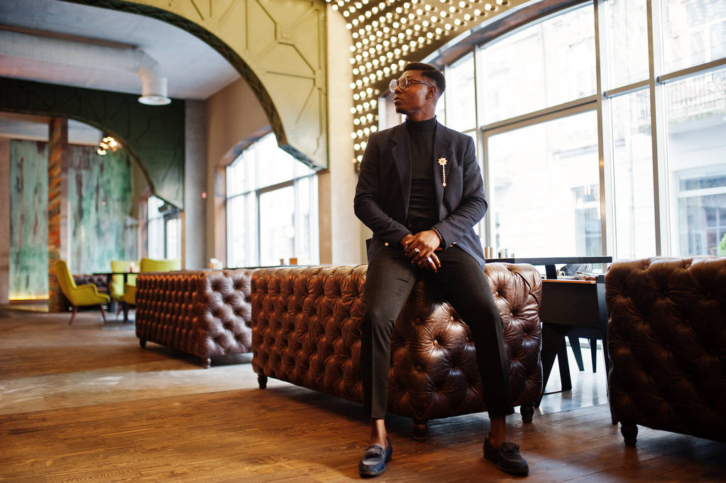 Modne african american człowiek w garniturze i okulary stwarzane w kawiarni. - Zdjęcie, obraz
