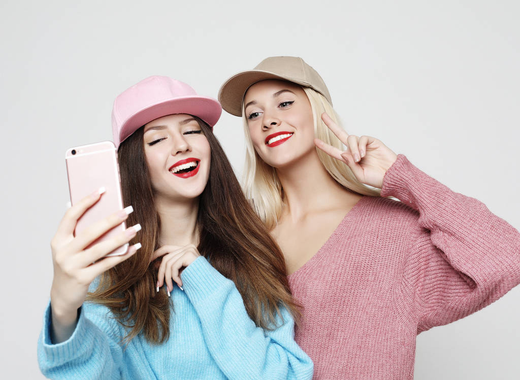 Dos amigas adolescentes en traje hipster hacen selfie
 - Foto, Imagen