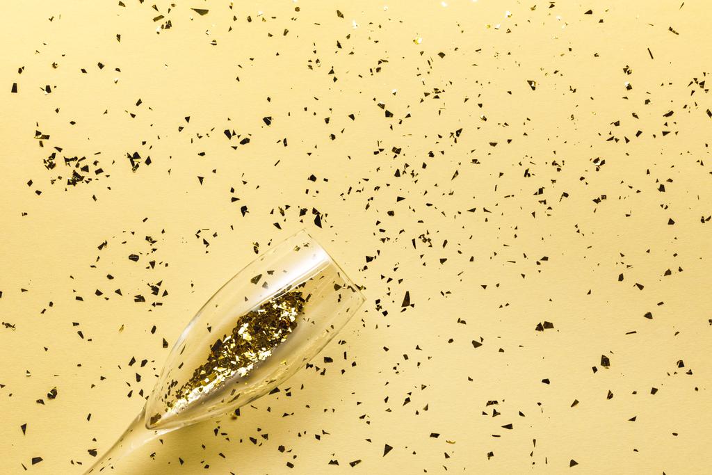 felülnézet pohár és ünnepi arany konfetti bézs háttér   - Fotó, kép