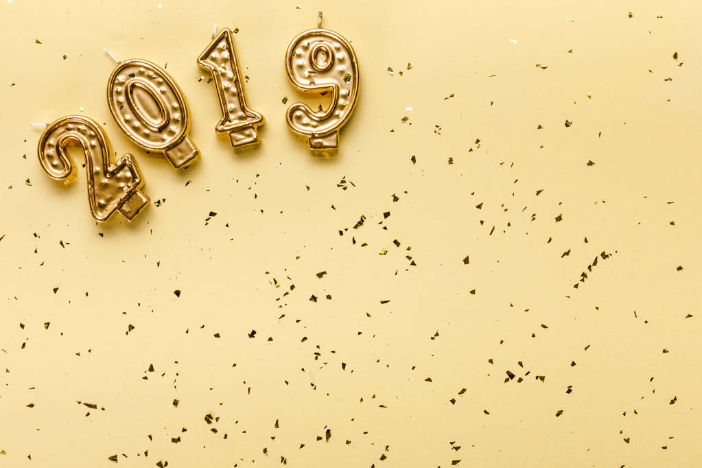 top view of 2019 candles and golden confetti on beige background - Photo, Image