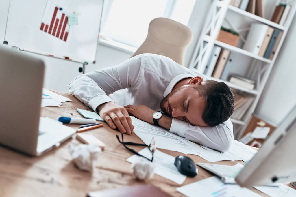 Überarbeiteter, müder Geschäftsmann schläft auf Schreibtisch  - Foto, Bild