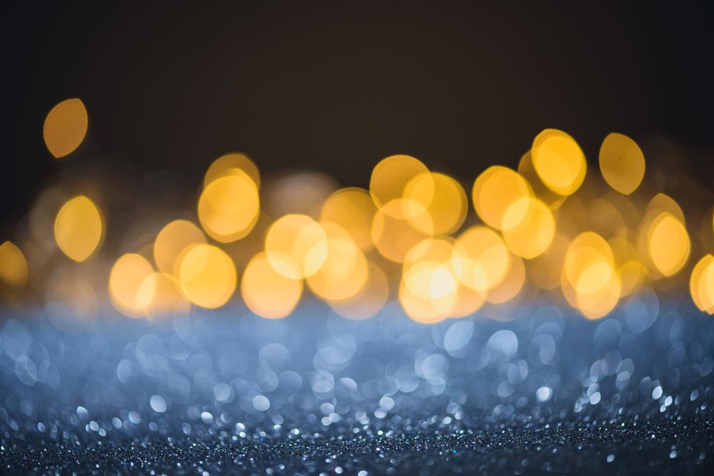 selective focus of blurred sparkling lights and bokeh on black - Photo, Image