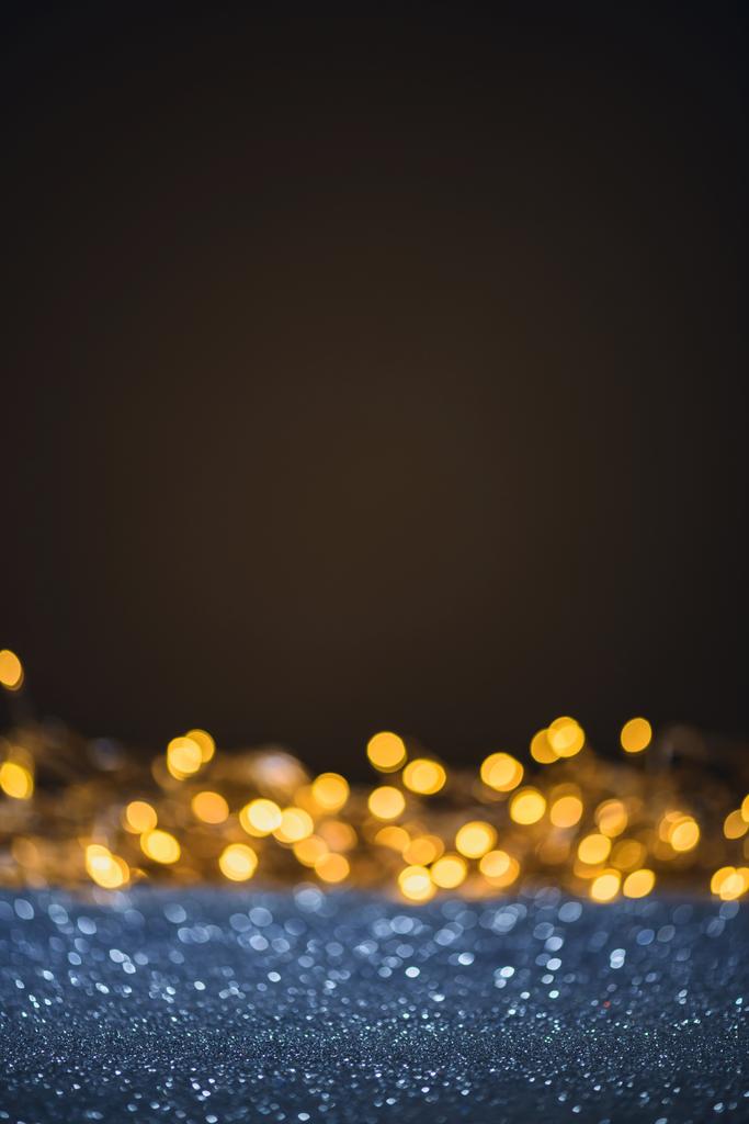 selective focus of blurred sparkling lights and bokeh on black - Photo, Image
