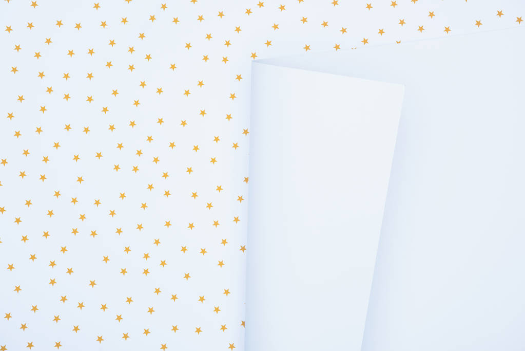 vue surélevée du papier blanc vide sur une surface festive décorée d'étoiles dorées
  - Photo, image